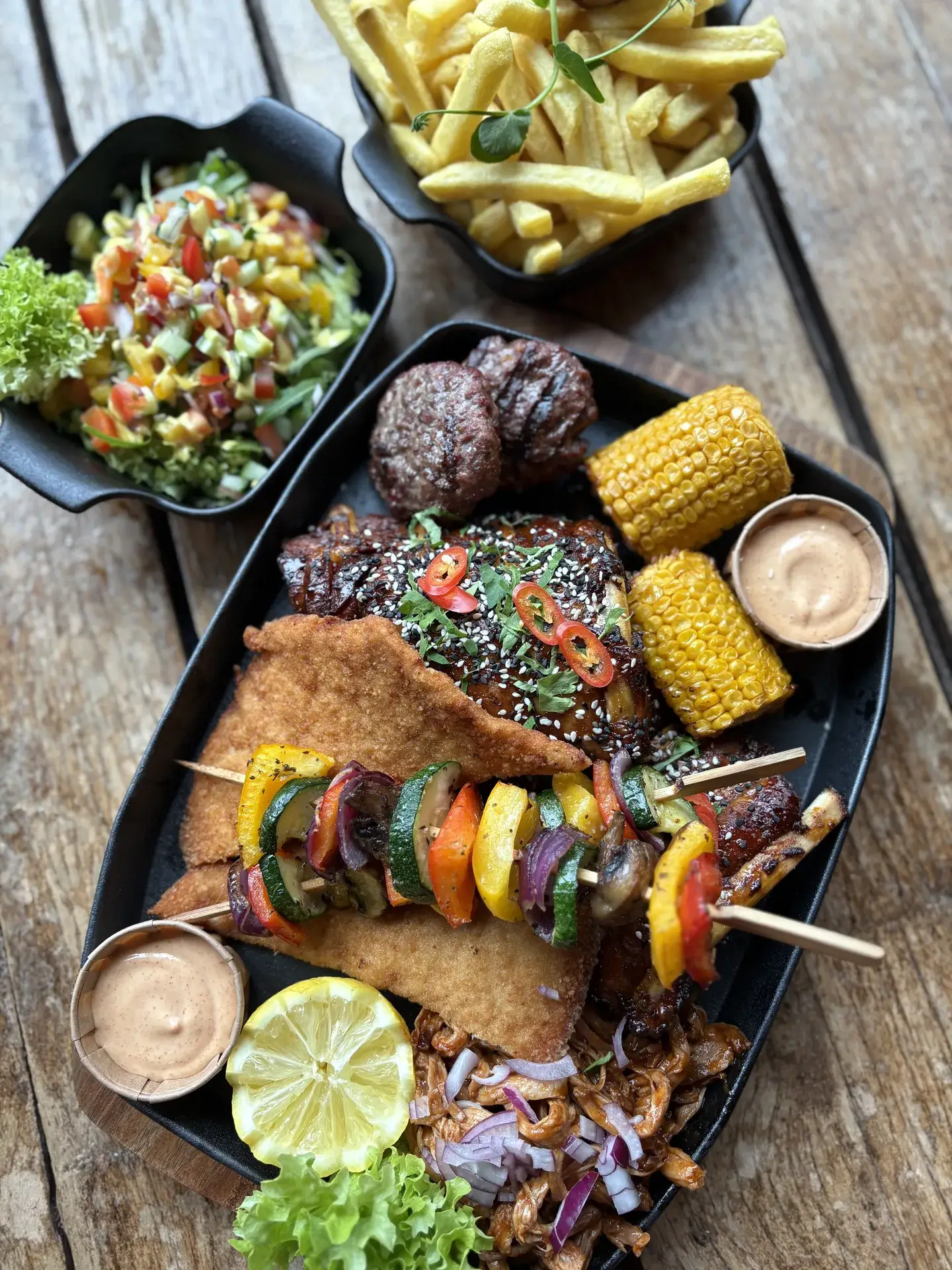 Sharing plank met mixed grill, spiesjes, friet en dips bij Club LEEN in Rozenburg