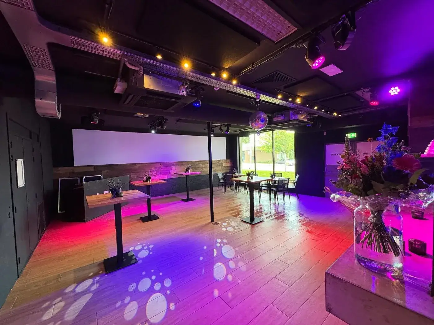 Feestzaal van Club LEEN met sfeerverlichting, podium en dansvloer
