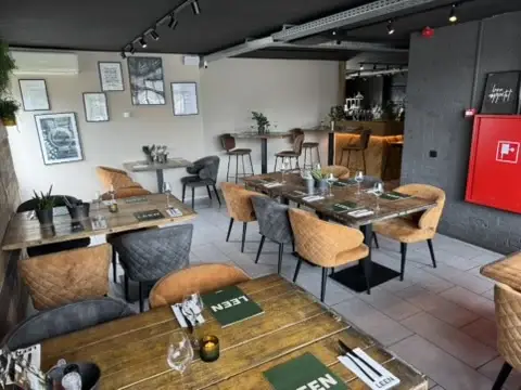 Gedekte tafels in De Eetkamer van Club LEEN met kunst aan de wand