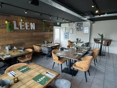Besloten eetkamer van Club LEEN met warme houten tafels en comfortabele stoelen