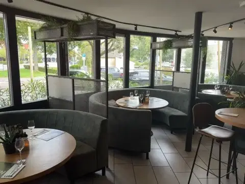 De Lounge van Club LEEN met ronde zitbanken, houten tafels en panoramische ramen