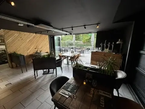 Tuinkamer van Club LEEN met donkere houten wanden en groen aan de vouwwand