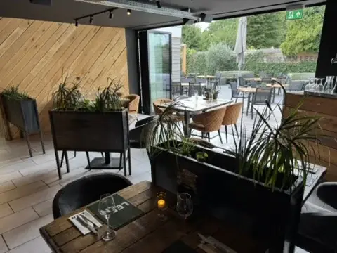 Zithoek in De Tuinkamer van Club LEEN met planten en zicht op de tuin