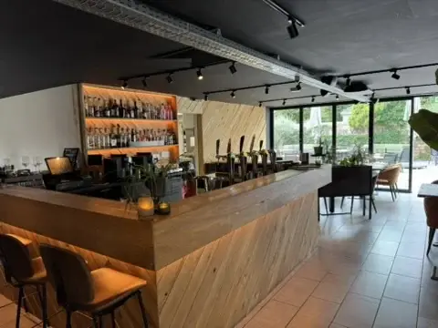 Houten bar in De Tuinkamer van Club LEEN met uitzicht op het groen