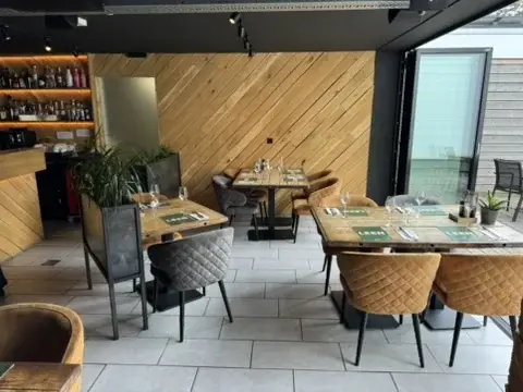 Gedekte tafels in De Tuinkamer van Club LEEN bij de houten wand