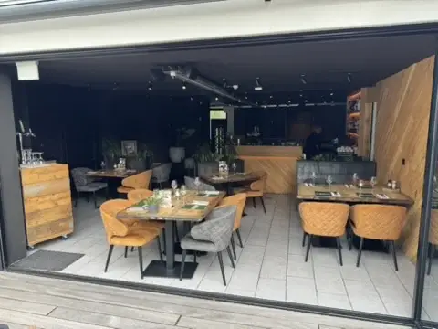 Tuinkamer van Club LEEN met geopende vouwwand naar de tuin